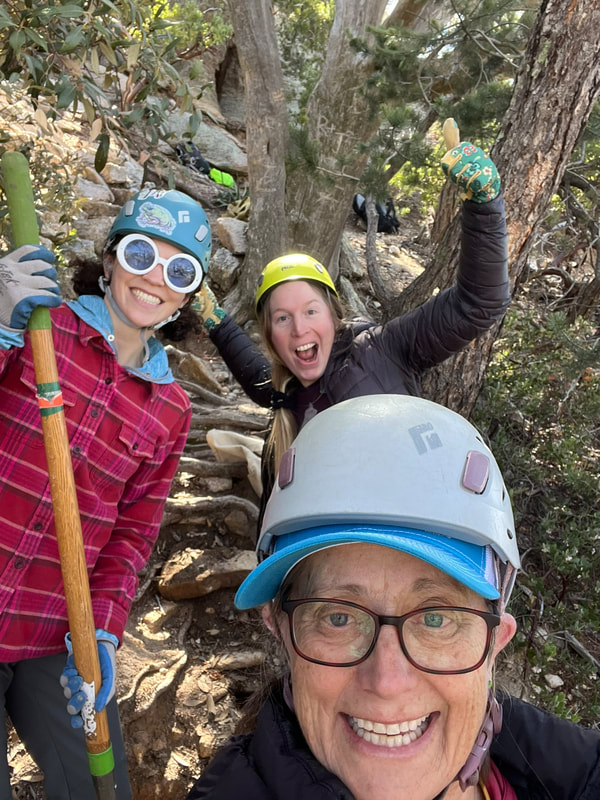 Three women celebrating hard trail erosion control efforts